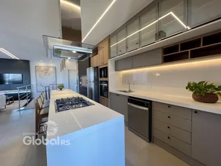 Vista da cozinha moderna com ilha e armários contemporâneos.
