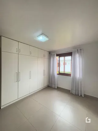 Imagem de uma sala com armários embutidos brancos.