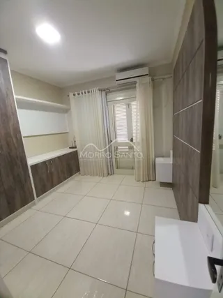Hall de entrada com piso claro e cortinas brancas.