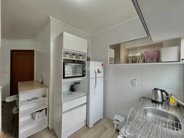 Foto de uma cozinha com armários brancos e eletrodomésticos modernos.