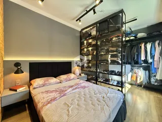 Quarto com cama e estante de roupas em ambiente moderno.