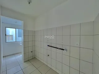 Hall de entrada com revestimento cerâmico branco nas paredes e piso.