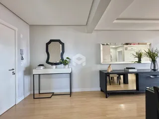 Sala de estar com piso de madeira clara e paredes brancas.