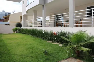 Fachada de uma residência em Lajeado, Brasil, com jardim gramado e grade branca.