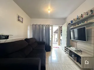 Sala de estar com sofá e piso de cerâmica clara.