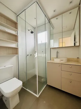 Foto de um banheiro moderno com box de vidro e bancada de madeira.