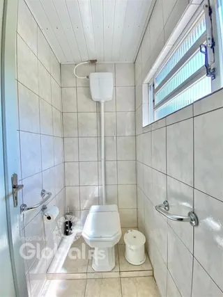 Foto de um banheiro com revestimento cerâmico nas paredes.