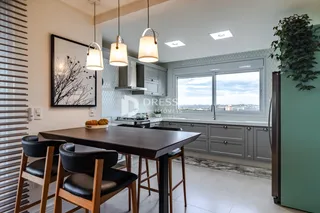 Sala de jantar com cozinha moderna e vista para a paisagem.