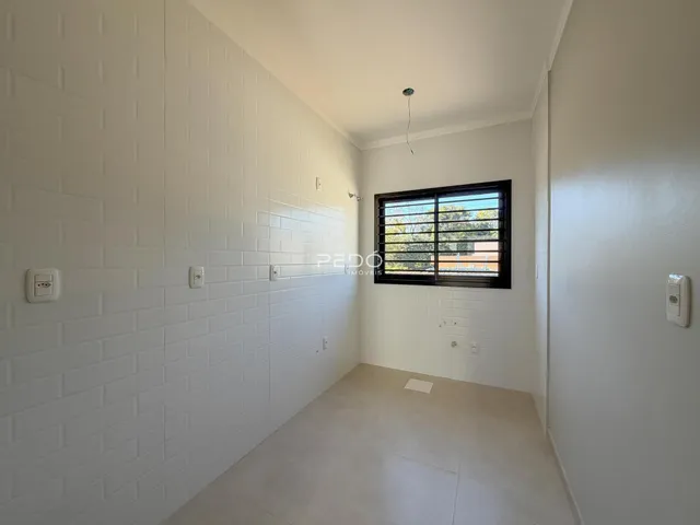 Hall de entrada com parede texturizada branca e piso claro.