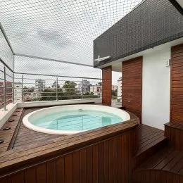 Foto da piscina externa com deck de madeira em uma residência.