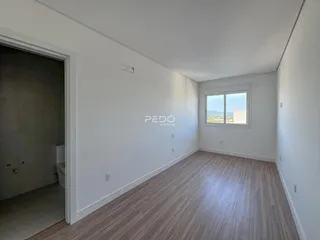 Ambiente interno de uma sala com piso de madeira clara.