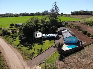Foto externa mostrando uma piscina e a área verde do imóvel em Lajeado.
