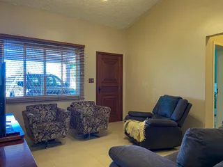 Esta é uma sala de estar com dois poltronas e um sofá escuro.