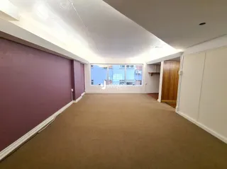 Corredor interno de uma residência com piso de carpete bege.
