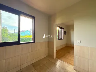 Hall de entrada com piso de cerâmica e porta aberta para outro ambiente.