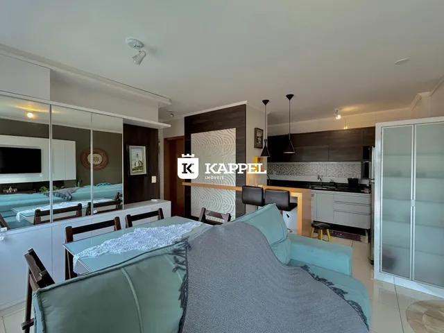 Sala de estar com sofá e mesa de jantar em um apartamento moderno.
