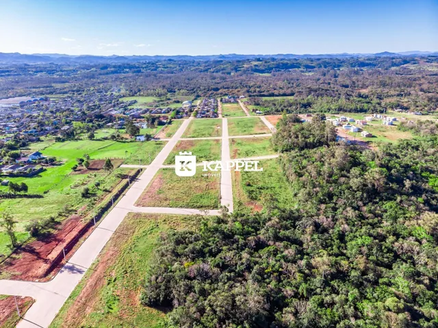 Vista aérea de uma propriedade rural com campos e vegetação ao redor.