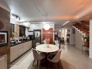 Vista interna de uma sala de jantar adjacente à cozinha em um imóvel no Brasil.