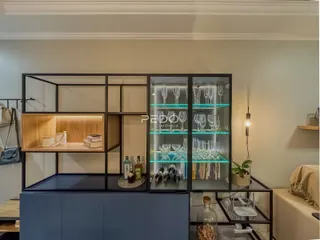 Uma estante de metal escura com portas de vidro decora o ambiente interno.