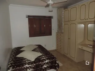 Quarto com cama e armário em ambiente residencial.