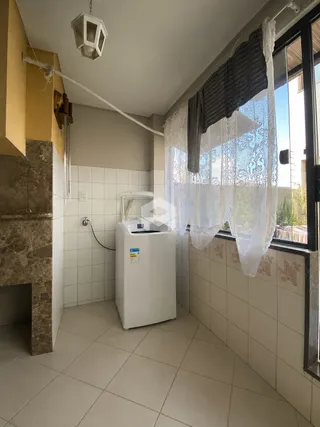 Foto de um ambiente interno com piso de cerâmica e máquina de lavar roupa.
