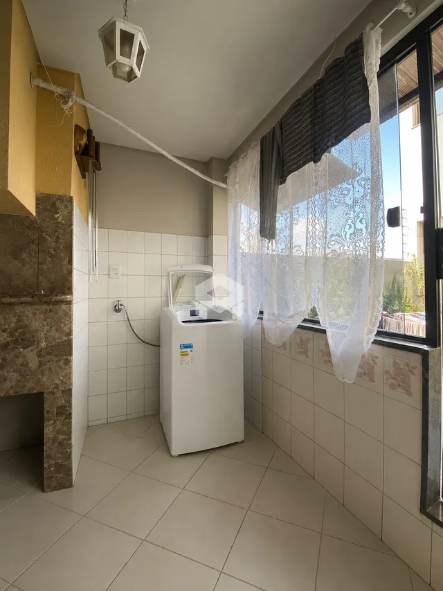 Foto de um ambiente interno com piso de cerâmica e máquina de lavar roupa.