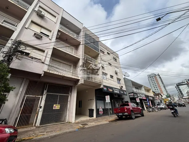 A fachada de um prédio residencial em Lajeado, Brasil, com estabelecimentos comerciais no térreo.