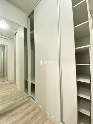 Corredor interno com armários embutidos em um imóvel.