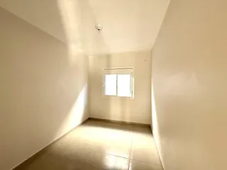 Corredor interno com piso de cerâmica e janela.