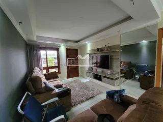 Sala de estar com sofá e janela em imóvel no Brasil.