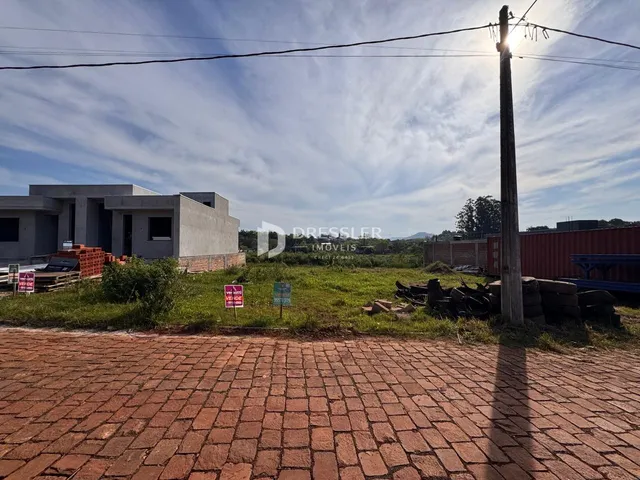 Vista externa de uma propriedade em Lajeado, Brasil, com área gramada e construção ao fundo.
