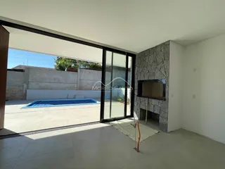 Vista da sala de estar com acesso a uma piscina externa.