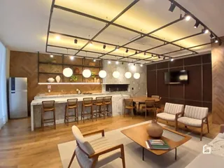 Interior de uma sala de estar com cozinha aberta em um imóvel no Brasil.