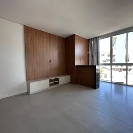 Sala de estar com paredes de madeira e grande janela que oferece vista externa.