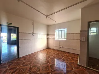 Vista interna de uma sala com piso de ladrilhos marrons.
