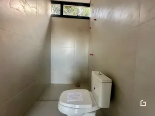 Foto de um banheiro interno com paredes brancas e piso de cerâmica.