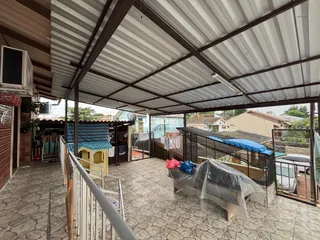 Vista de uma área externa coberta com estrutura de telhado metálico.