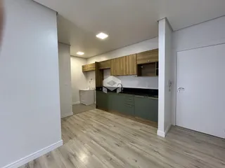 Foto da cozinha com armários de madeira e piso claro em imóvel no Brasil.