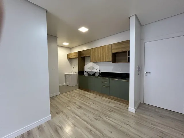 Foto da cozinha com armários de madeira e piso claro em imóvel no Brasil.