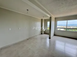 Espaço interno com piso de cerâmica e grande janela.