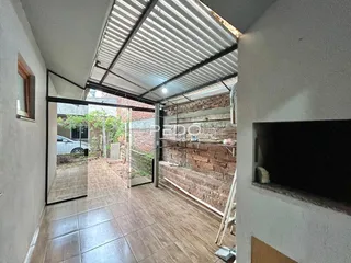 Corredor interno com piso de cerâmica e parede de tijolos expostos.