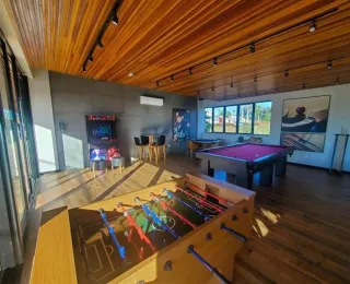 Foto de uma sala com piso de madeira e mesa de bilhar.
