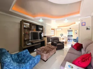 Sala de estar com teto arqueado e iluminação quente.