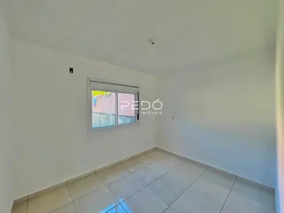 Interior de um cômodo com paredes brancas e piso de cerâmica.