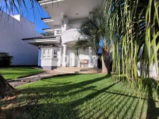 Fachada de uma casa branca com jardim verde em Lajeado, Brasil.