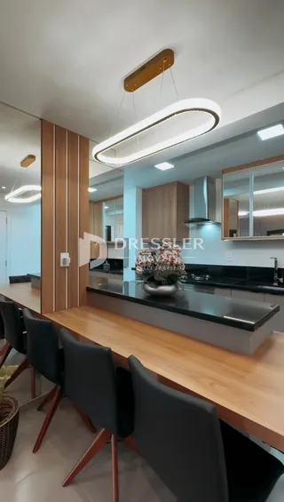 Vista da cozinha moderna com armários de madeira e bancada escura.