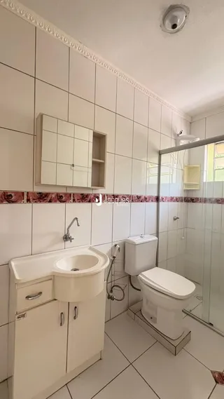 Foto de um banheiro com azulejos brancos e louças sanitárias.