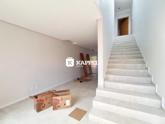 Hall de entrada com escadaria e caixas de mudança em ambiente interno.