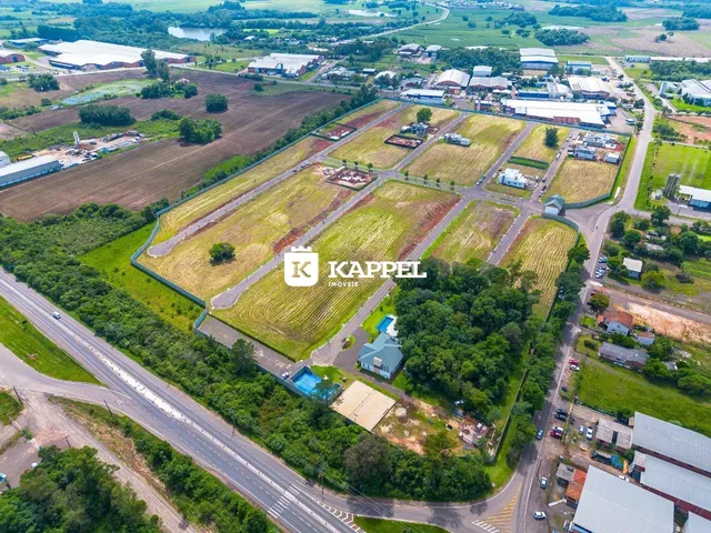 Vista aérea de um terreno com campos agrícolas e uma estrada adjacente.