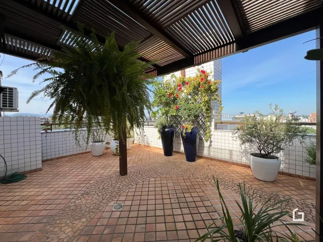 Vista de uma área externa com piso de tijolos e vegetação em Lajeado.